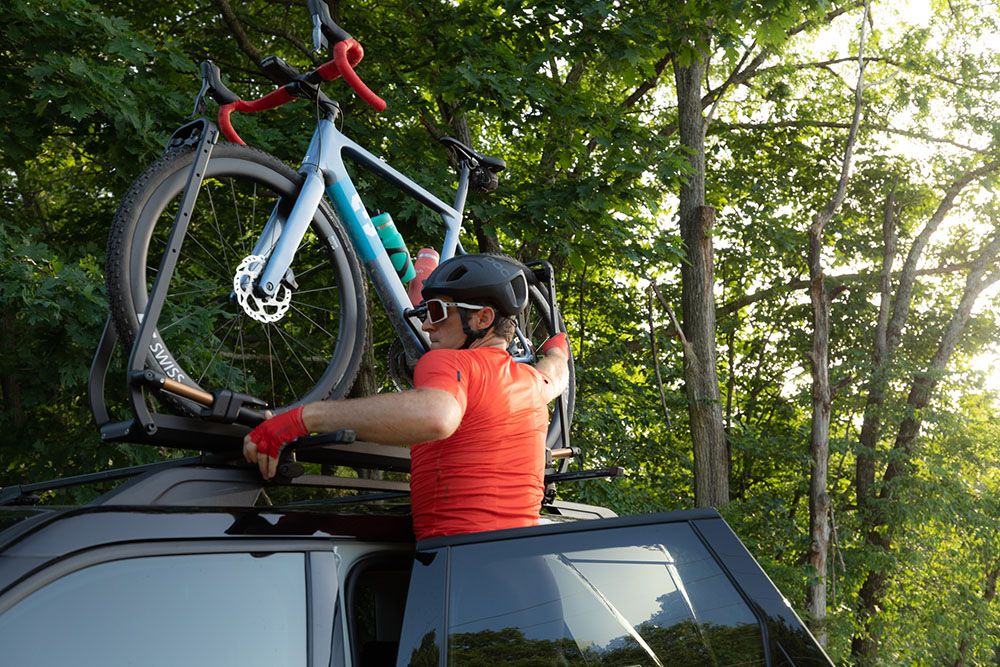 A man loading a bike on a rooftop bike rack