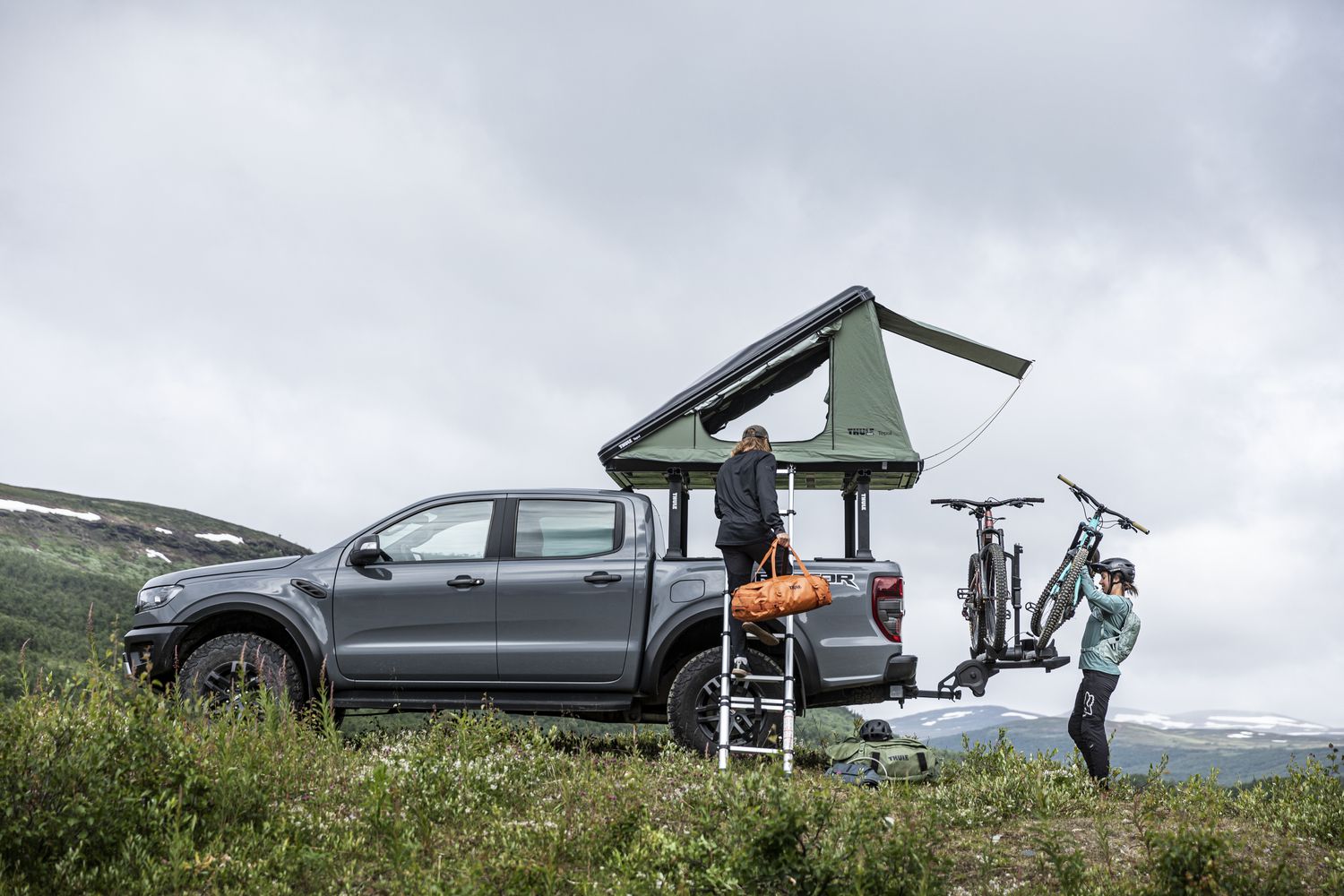 A car with a rooftop tent and a bike rack