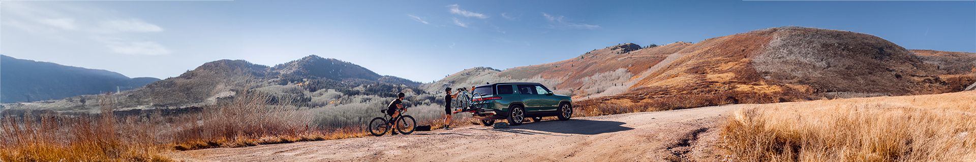 A dirt road with a car and two bikes