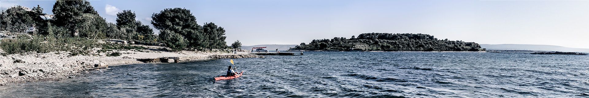 A kayaker paddling near a shoreline